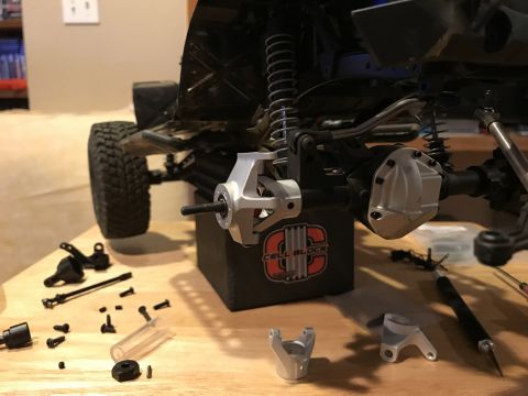 1989 Ford Bronco - RC car chassis undergoing assembly with various metal and plastic components laid out.