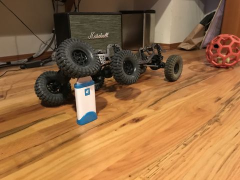 1989 Ford Bronco - This RC rock crawler chassis is shown from a side angle on a wooden floor, with a Marshall amplifier in the background.