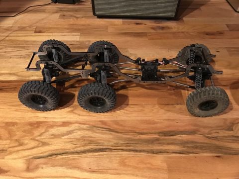 1989 Ford Bronco - This is a six-wheel drive RC crawler chassis with visible suspension and drivetrain components.