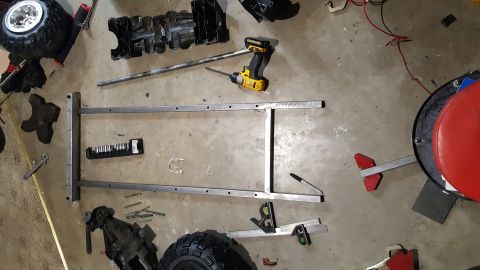 2007 Subaru Impreza - Various parts, tools, and a metal frame are laid out on a concrete floor, suggesting a project or repair in progress.