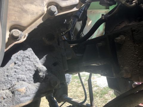 1979 Ford Bronco - Undercarriage view of a vehicle's engine and suspension components, covered in dirt and grime.