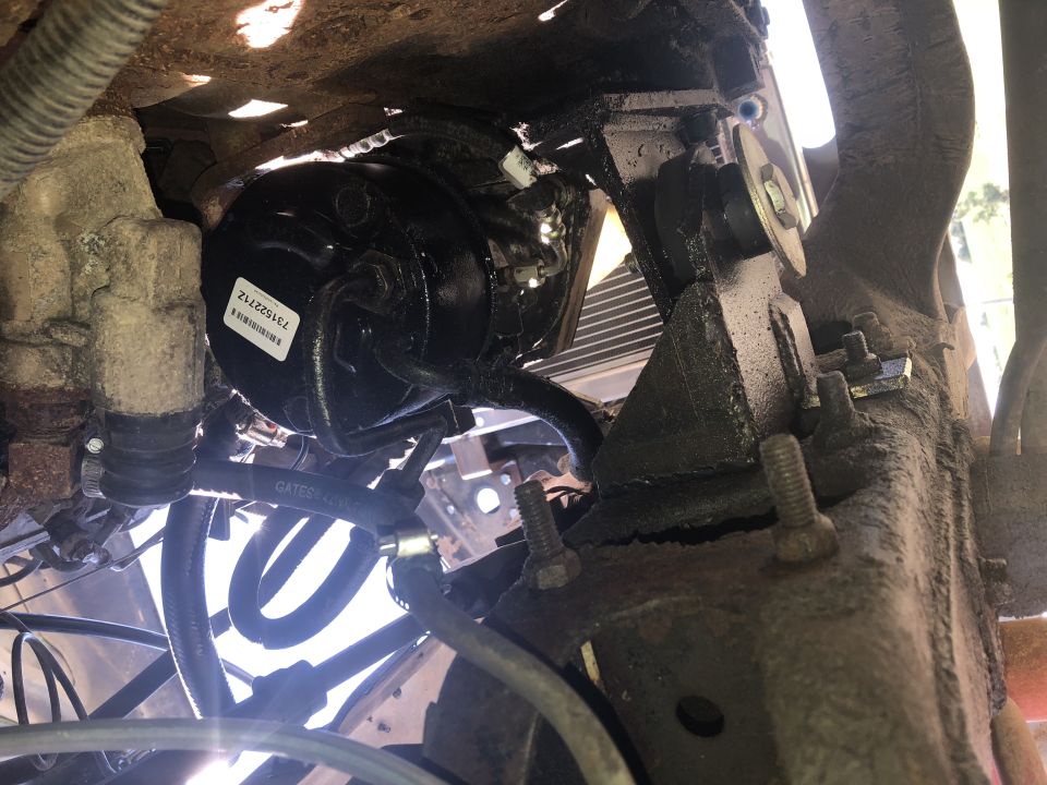 Close-up of brake booster with part number 731522712 on a rusty vehicle frame.