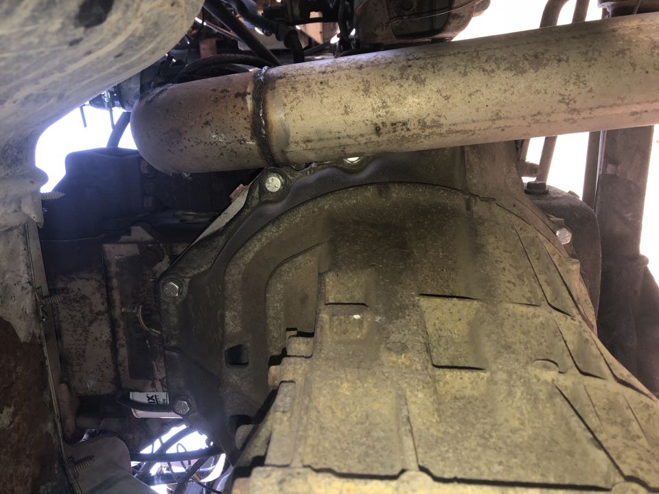 Underside view of a vehicle transmission and exhaust pipe.