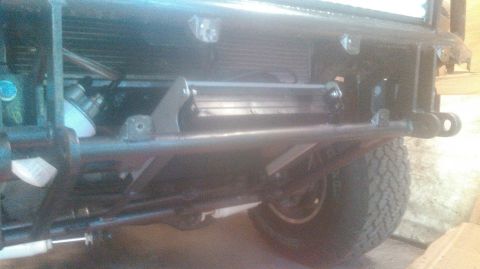 1992 Ford Bronco - The front bumper area of a vehicle is shown, featuring a winch mounted below the radiator. A portion of the front tire and suspension is vi…