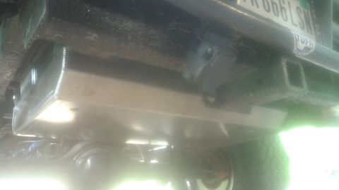 1992 Ford Bronco - The underside of a vehicle shows a trailer hitch and a protective skid plate.