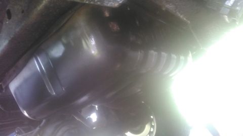 1992 Ford Bronco - Underside view shows the oil pan and part of the frame of a vehicle.