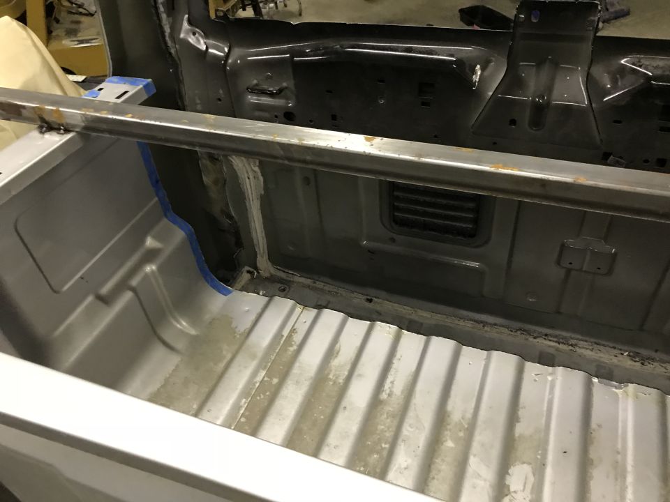 Interior of a pickup truck bed with a metal bar across the top