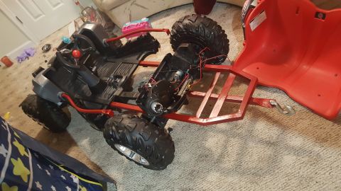 2007 Subaru Impreza - A toy ATV is shown upside down on a carpeted floor, revealing its internal components and detached red seat.