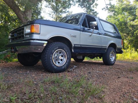 1989 Ford Bronco - This 1989 Ford Bronco features a two-tone paint scheme with blue and silver sections.