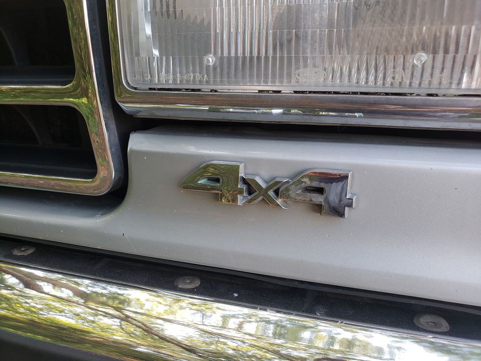 Close-up of 1989 Ford Bronco 4x4 emblem on front fender