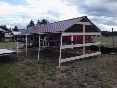 1995 Ford Bronco - A partially constructed barn with a metal roof and wooden beams is shown outdoors.