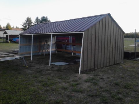 1995 Ford Bronco - An unfinished shed with a metal roof and wooden siding is shown outdoors.