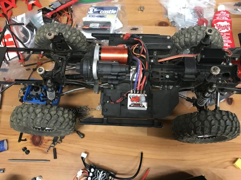 1989 Ford Bronco - The chassis of a remote control car, showing its motor, wiring, and suspension components.