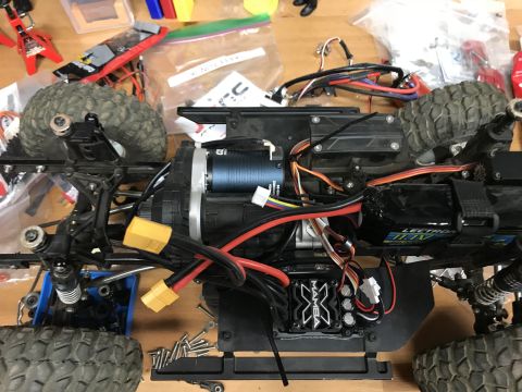 1989 Ford Bronco - Close-up of an RC car's internal components, including the motor, electronic speed controller, and battery connections.