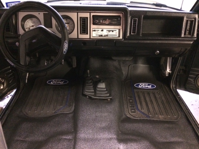 Truck interior with Ford floor mats and steering wheel cover
