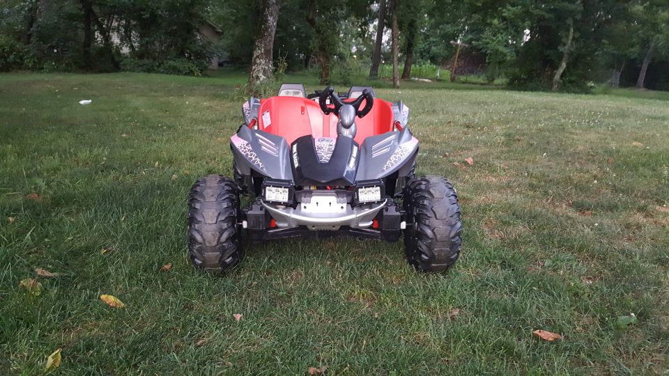 Toy dune buggy with large knobby tires and two seats, parked on grass