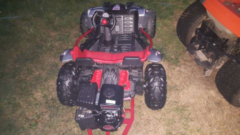 2007 Subaru Impreza - A toy dune buggy with a visible gas engine and red frame is parked on grass next to a lawnmower.