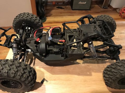 1989 Ford Bronco - RC rock crawler chassis with large tires and visible motor. A key lies nearby.