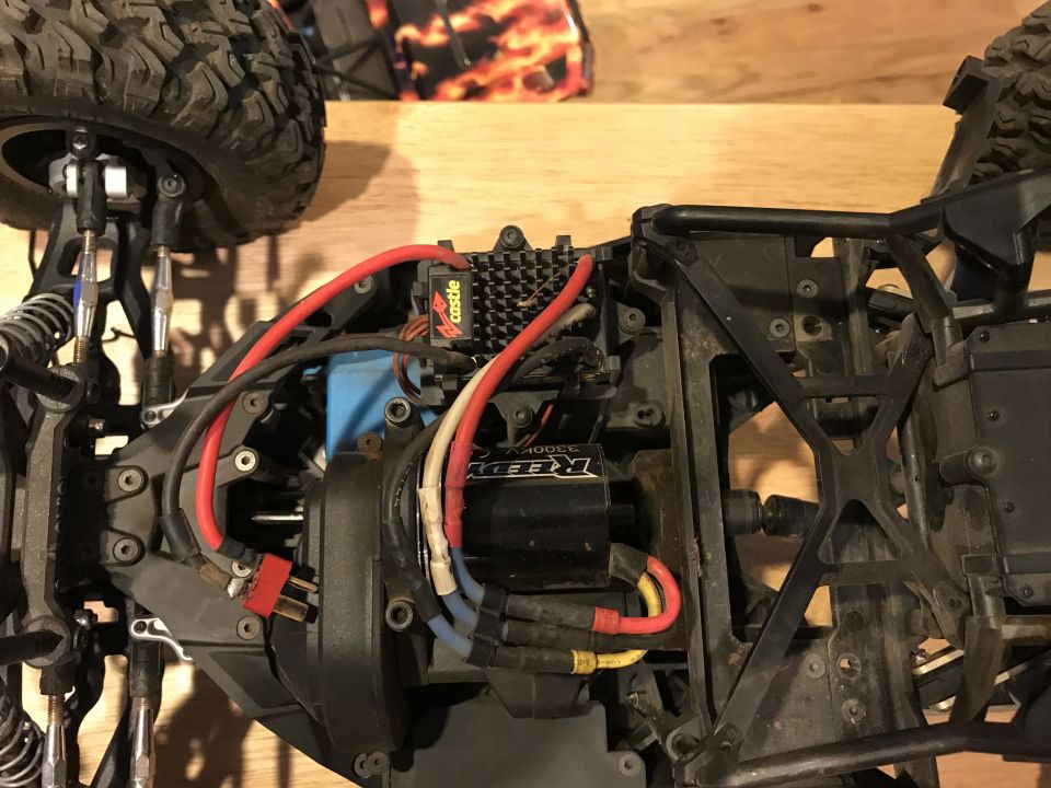 RC car chassis with red and black wires, a blue component, and a black motor labeled Reedy