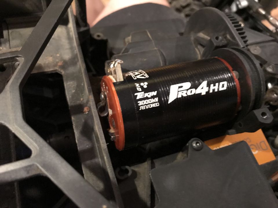 Tekin Pro4 HD 3000KV motor with orange end cap, part of an RC car