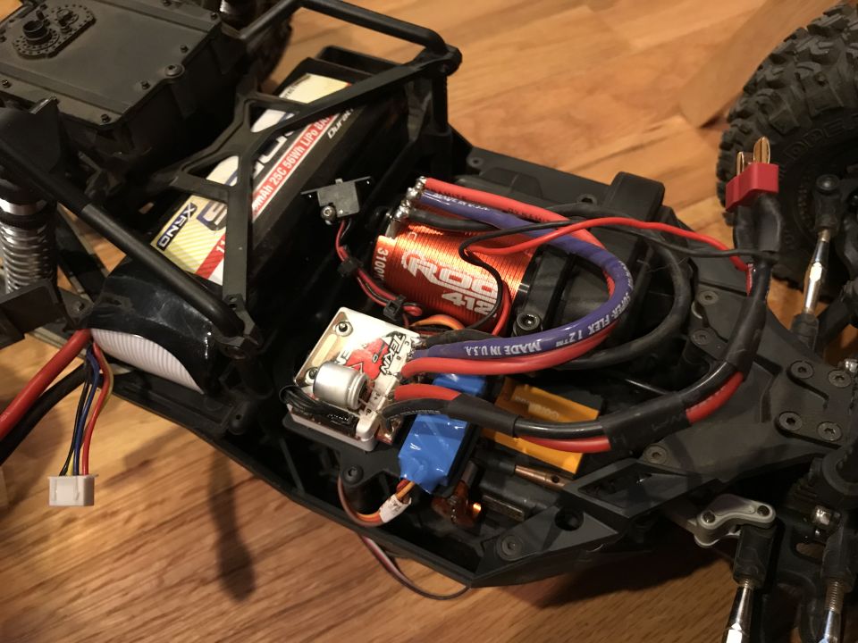 RC car chassis with battery, motor, and wiring visible