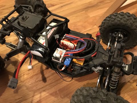 1989 Ford Bronco - The internal components of a remote control car are visible, including the motor, battery, and electronic speed controller.