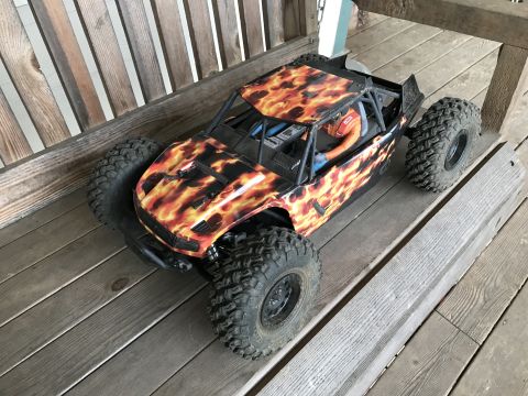 1989 Ford Bronco - Remote control rock crawler with flame graphics sits on a wooden surface.