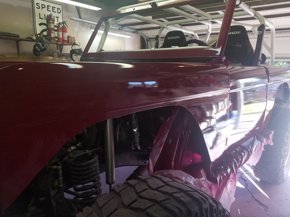 Red 1968 Ford Bronco interior with roll cage and Bride seats