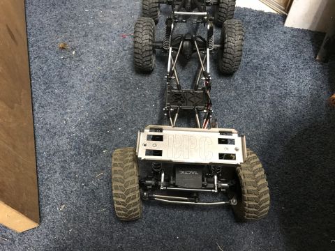 1989 Ford Bronco - This RC car chassis features a metal plate with 'BPC' etched into it, and large off-road tires.