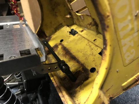 1989 Ford Bronco - Close-up of a yellow RC car chassis interior, showing mechanical components and signs of wear.