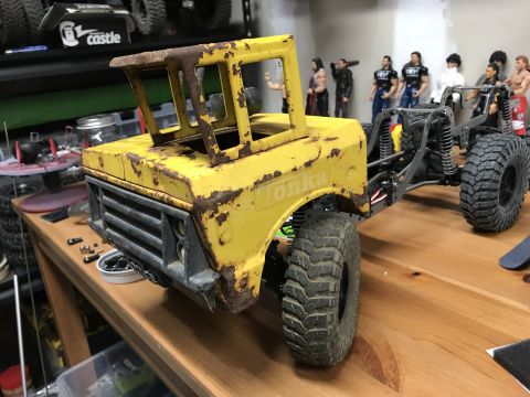 1989 Ford Bronco - This weathered RC truck body, labeled 'Tonka', is part of a project on a wooden workbench, with toys and parts scattered around.