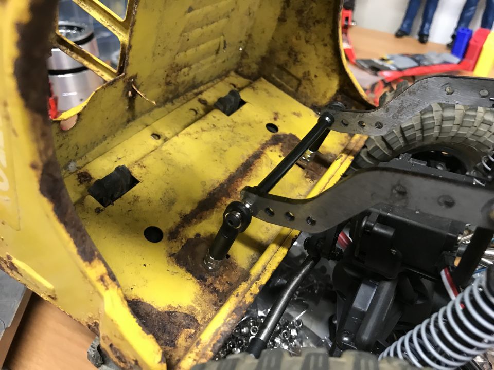 Yellow RC car chassis interior with suspension and steering components