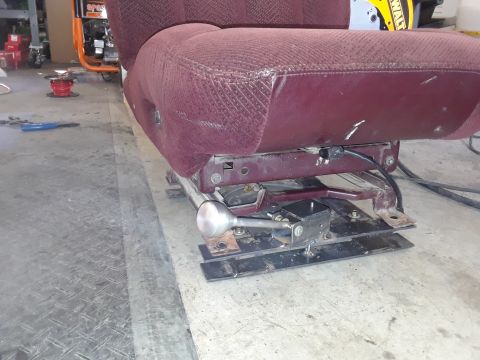 1999 Ford E250 - Close-up of a maroon fabric seat, showing its slider mechanism and adjustment lever.
