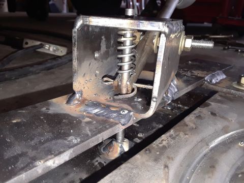 1999 Ford E250 - This photo shows a custom-fabricated metal bracket with a spring, likely a component for a vehicle.