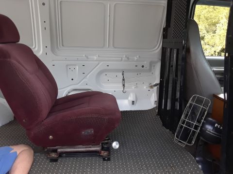 1999 Ford E250 - Interior view of a van's cargo area, showing a single maroon seat and partition.