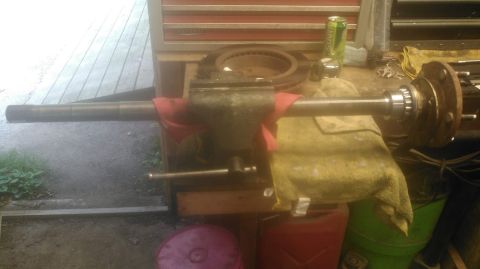 1978 Ford Bronco - A rear axle assembly, including a brake rotor and hub, is secured in a vise on a workbench.