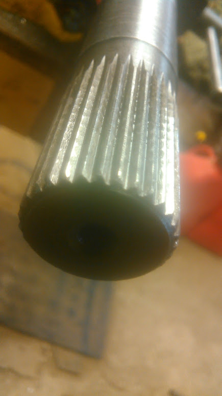 1978 Ford Bronco - Close-up of a splined shaft end, partially submerged in dark fluid, with Supermotors.net logo visible.