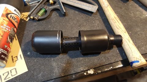 2007 Subaru Impreza - A custom exhaust muffler part is shown on a workbench with tools and spray paint.