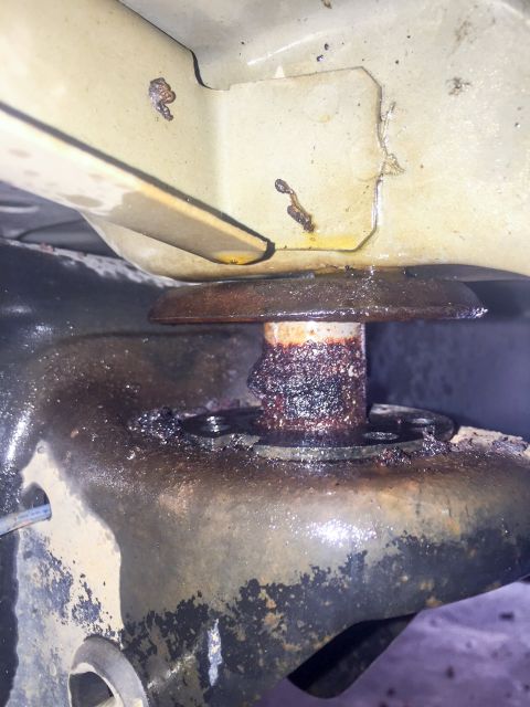 2003 Ford Explorer - A close-up view of a corroded vehicle suspension component, showing significant rust and dirt accumulation.