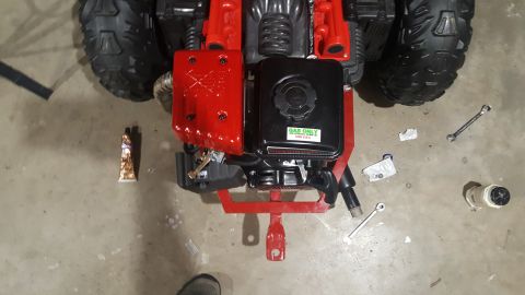 2007 Subaru Impreza - Small engine with red cover and black gas tank, tools and sealant on concrete floor.