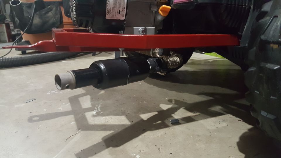 Exhaust pipe attached to a red frame with a black engine component above