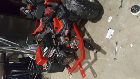 2007 Subaru Impreza - A red and black go-kart is shown with its engine and a large tire visible.