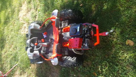 2007 Subaru Impreza - Toy ATV with a gas engine modification, seen from underneath while resting on its side in the grass.