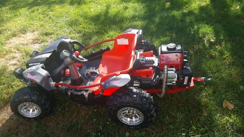 2007 Subaru Impreza - This go-kart has a red seat and a visible engine at the rear, parked on a grassy area.
