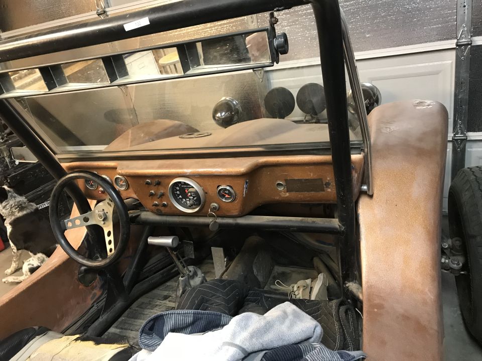 Interior of a dune buggy showing wood dash, gauges and steering wheel