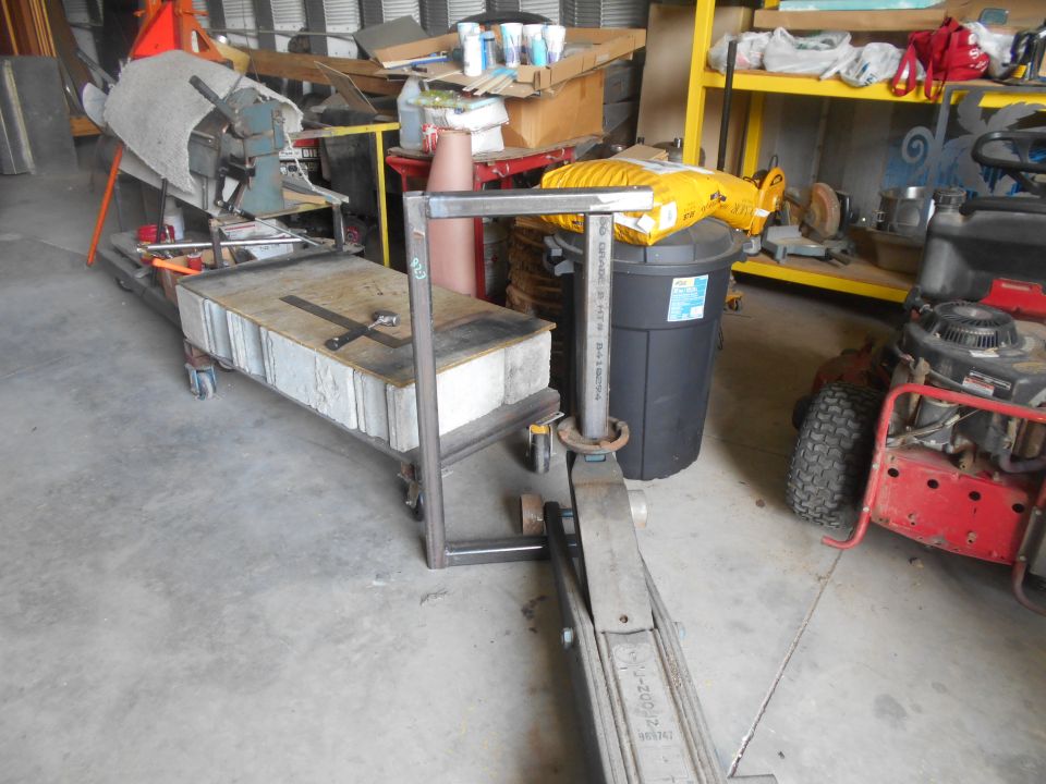 Metal frame structure over a hydraulic jack in a workshop.