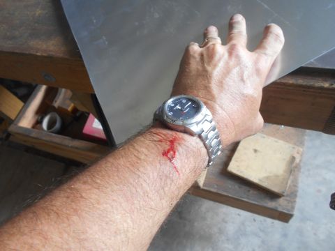 1992 Ford Bronco - A person's arm with a watch and a bleeding cut is held up near a sheet of metal. The metal appears to be a work in progress, possibly for a…