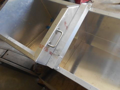 1992 Ford Bronco - A close-up view of a custom-made aluminum box with a handle, likely a modification or part for a vehicle. The box has visible markings and…