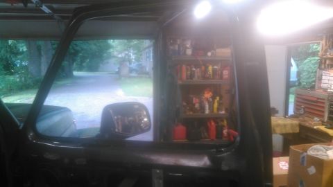 1992 Ford Bronco - Interior view of a dark-colored vehicle, likely a 1992 Ford Bronco, showing the driver's side door and window frame. The background reveals…