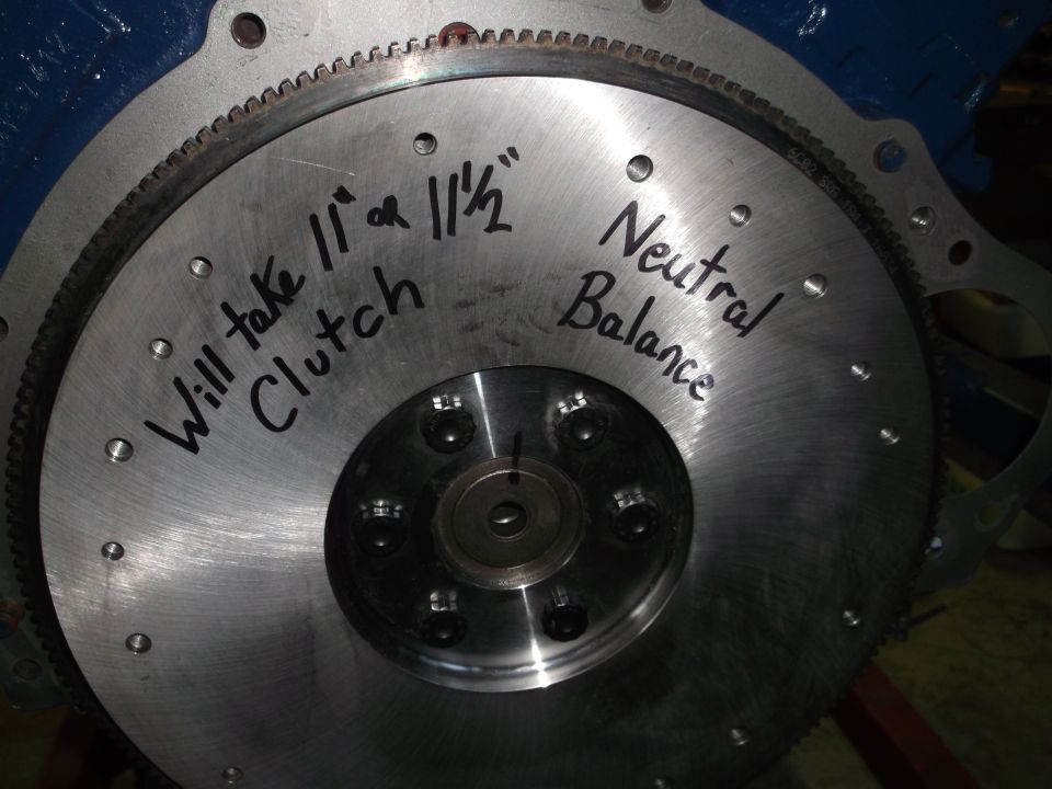 Close-up of a flywheel with handwritten text about clutch size and balance.
